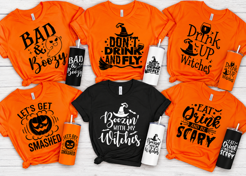 Orange and black Halloween-themed t-shirts and tumblers with various spooky sayings.