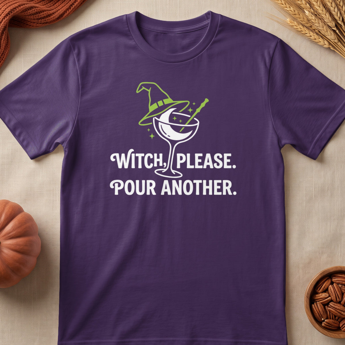 Purple t-shirt with witch hat cocktail graphic and text "Witch, please. Pour another."