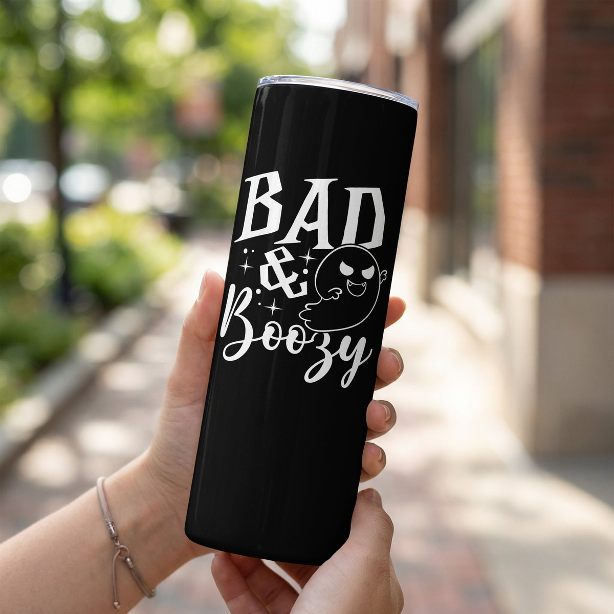 Black tumbler with white text "BAD & Boozy" and a ghost graphic.